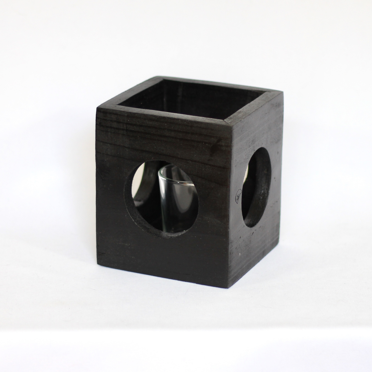 Black modern minimalist Cube-shaped wooden candle holder with circular cutouts showing glass votive holder