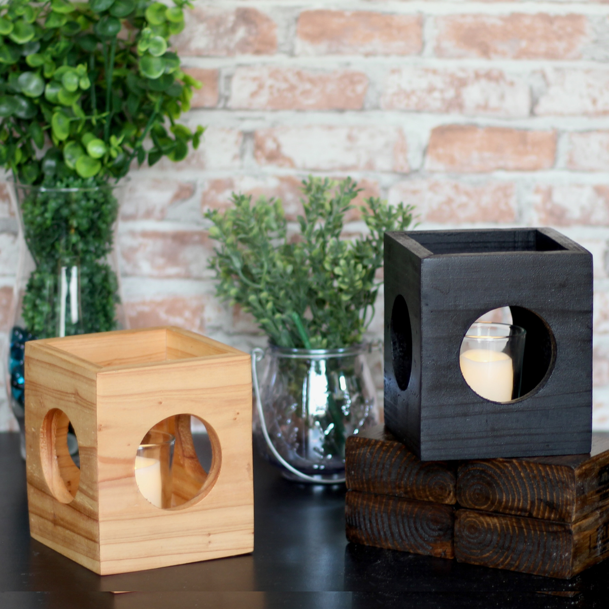 Light wood and Black modern minimalist Cube-shaped wooden candle holder with circular cutouts showing glass votive holder
