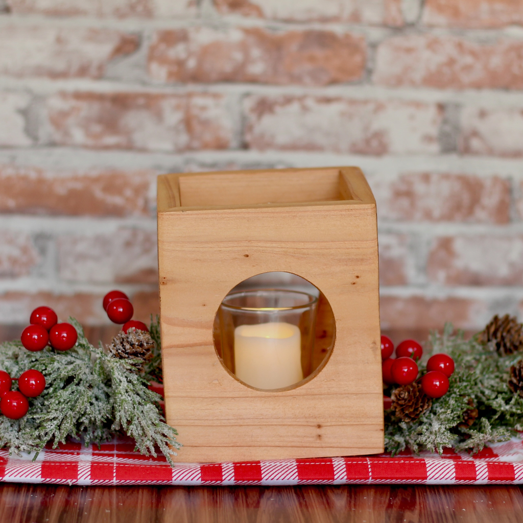 Cube-shaped wooden candle holder with circular cutouts showing glass votive holder holiday centerpiece