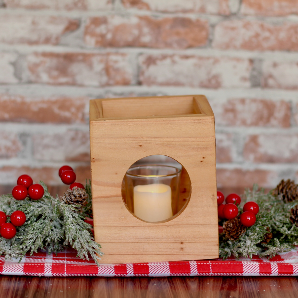 Cube-shaped wooden candle holder with circular cutouts showing glass votive holder holiday centerpiece