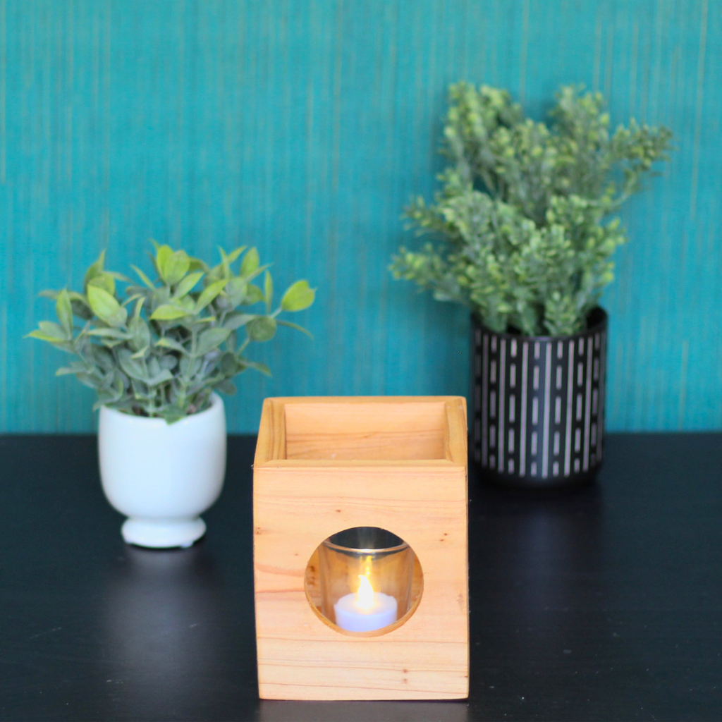 Light wood modern minimalist Cube-shaped wooden candle holder with circular cutouts showing glass votive holder